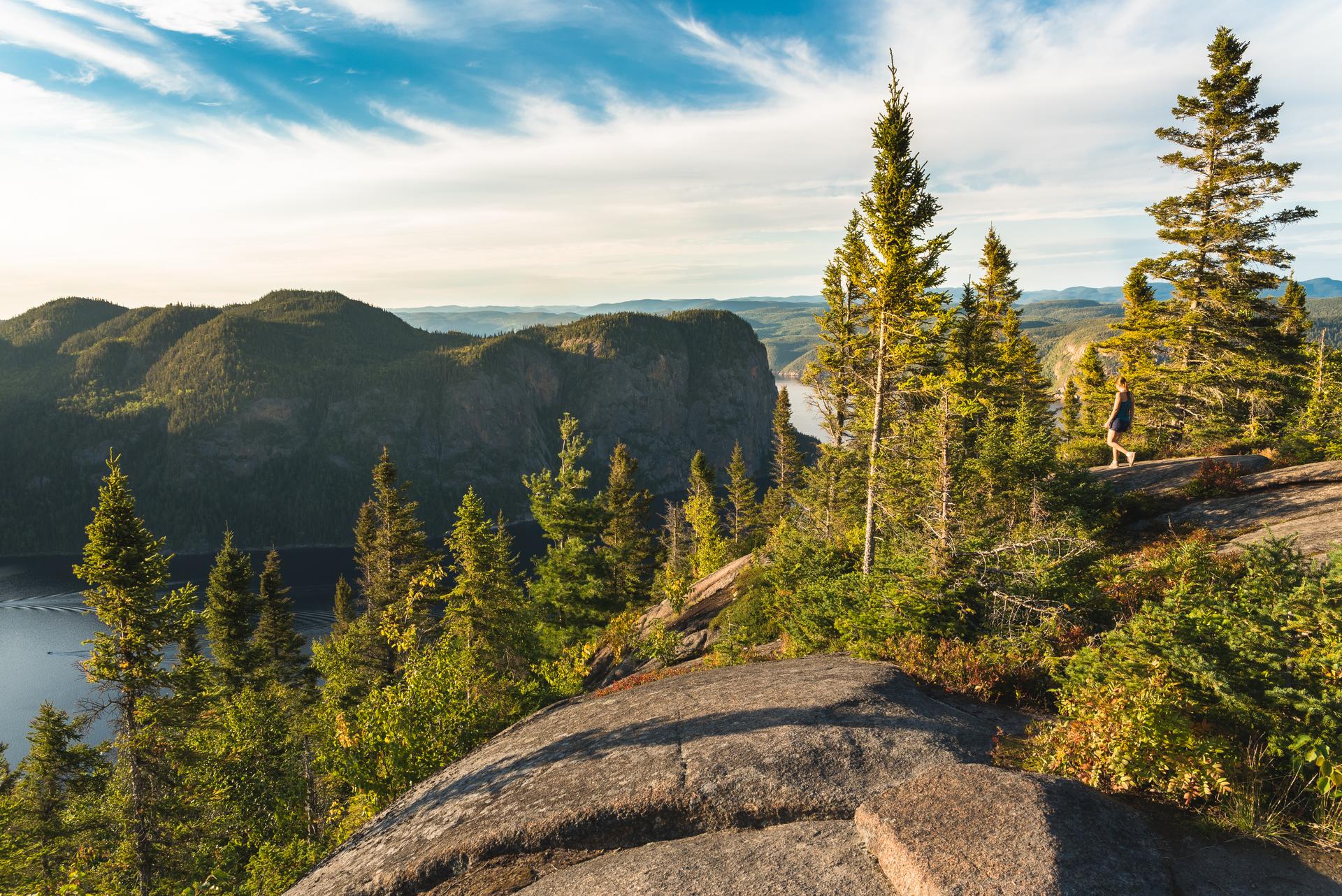 A person hiking on a bluff above Rivière-Éternité in Quebec.