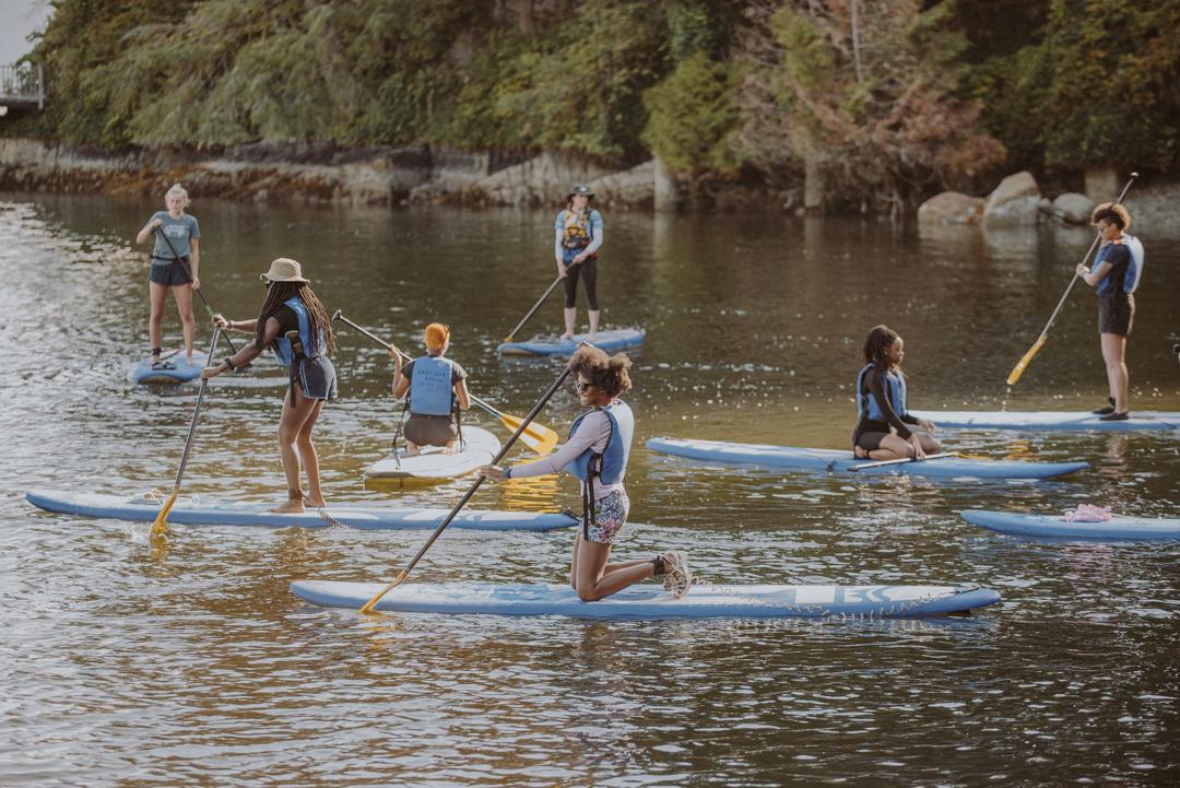 A group of stand up paddleboarders in the water
