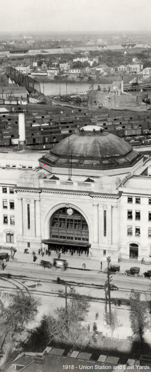 An old black-and-white photograph from 1918 shows Union Station and the East Yards in Winnipeg, featuring a grand entrance with a large dome and the surrounding industrial area.