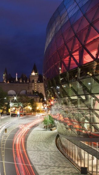 A nighttime view of the illuminated Shaw Centre in Ottawa, Canada