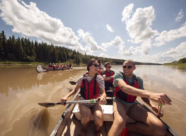 Des gens prennent part à l’expérience en canot voyageur, excursion guidée sur la même rivière qu’ont empruntée les premiers explorateurs.